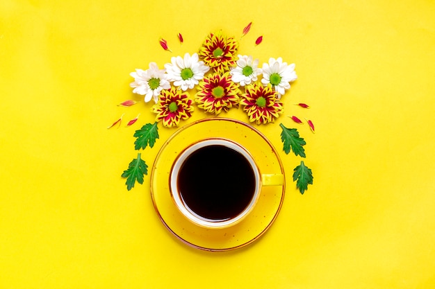 Fiori, foglie verdi e tazza di caffè caldo