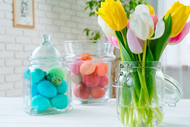 Fiori freschi della molla con le uova dipinte per la celebrazione di Pasqua