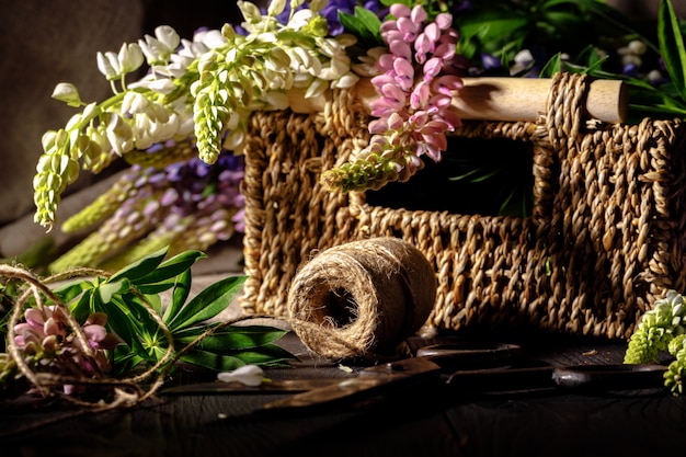 Fiori freschi, foglie e strumenti per creare un bouquet su un tavolo, sul posto di lavoro del fiorista