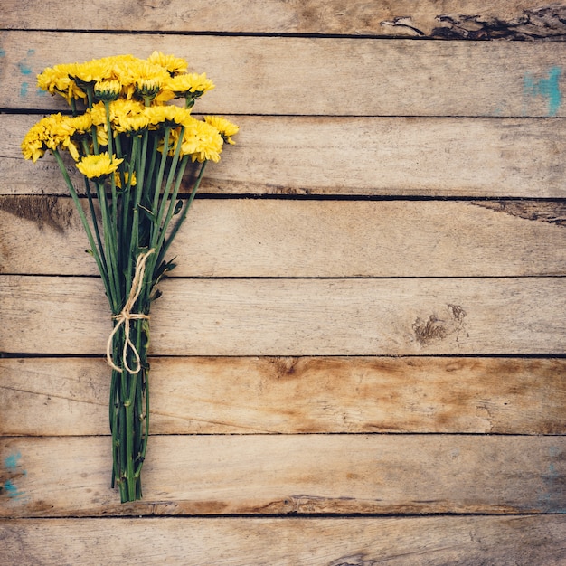 Fiori gialli di bouquet, vista dall'alto su texture di sfondo in legno con spazio di copia