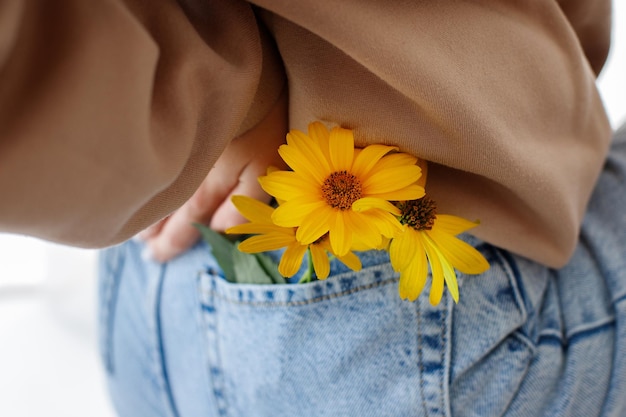 Fiori gialli nell'umore del primo piano della tasca dei jeans