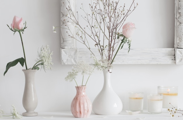 Fiori in un vaso e candele su spazio bianco