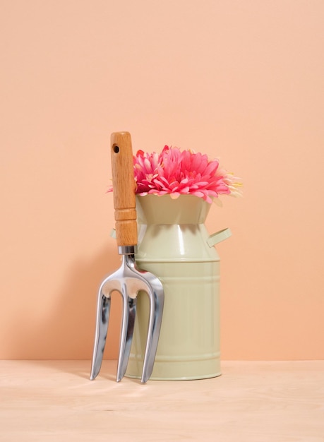 Fiori in un vaso verde e una piccola forchetta da giardino Lavoro agricolo nella piantagione