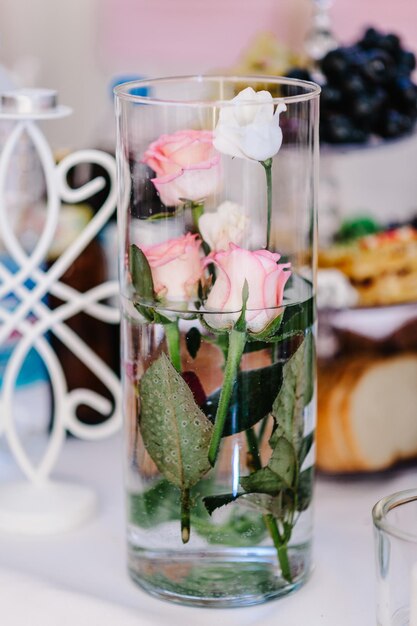 Fiori in vaso in una festa di matrimonio. Tavola festiva decorata con composizione bianca, rose rosa e verde nella sala banchetti. Tavolo sposini nell'area banchetti.