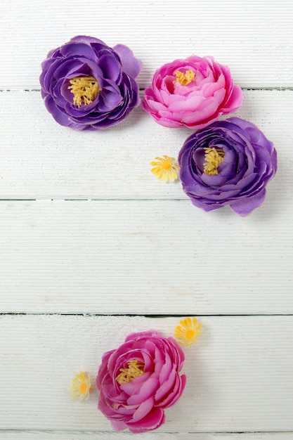 Fiori rosa e viola falsi isolati su un fondo bianco.