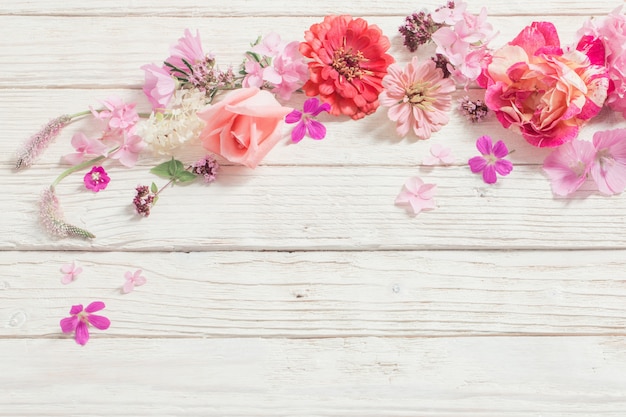 Fiori rosa su fondo di legno bianco