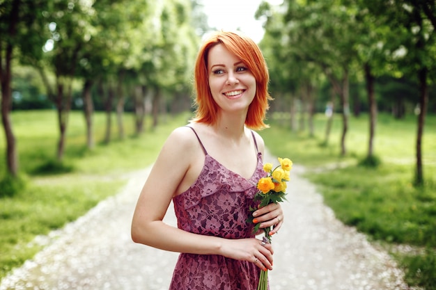 Fiori rossi della primavera della tenuta della donna di Heair