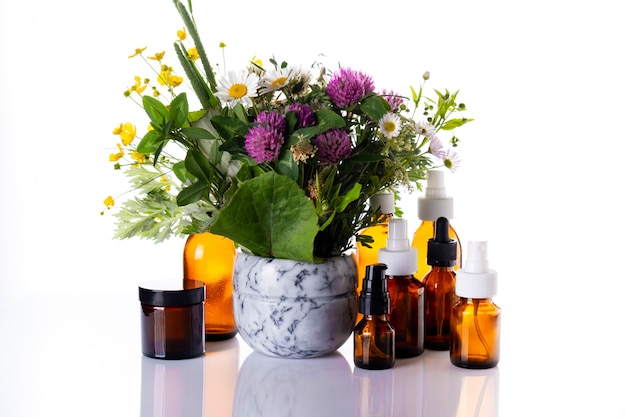 Fiori selvatici in un mortaio di marmo e una bottiglia di vetro medicinale con olio essenziale, oli cosmetici, aromaterapia, fitoterapia, medicina alternativa, cura della pelle naturale.