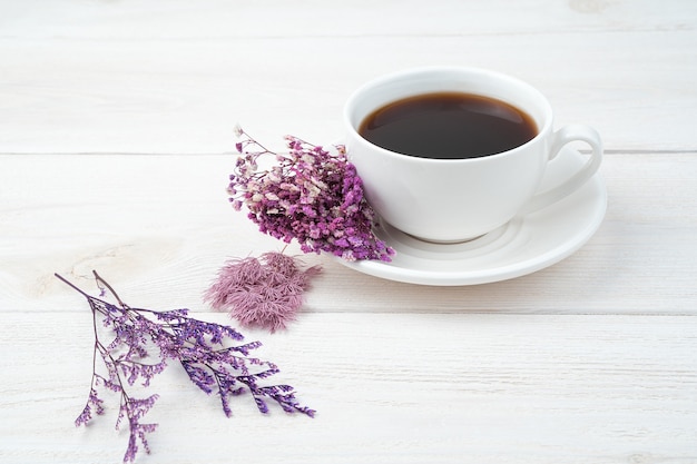 Fiori viola e caffè su uno sfondo bianco. Vista laterale, con spazio per copiare.