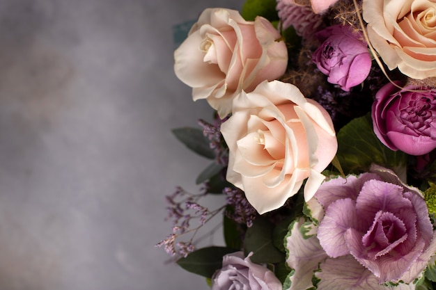 Fiorisca il bordo dei fiori freschi assortiti su una priorità bassa grigia. immagine orizzontale, copia spazio, vista dall'alto