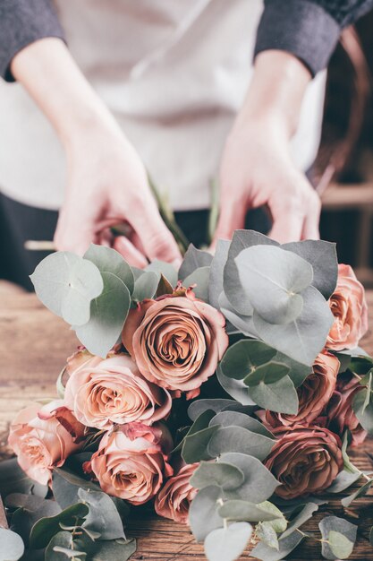 Fiorista al lavoro sul bouquet di fiori arrangment