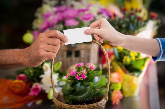 Fiorista che dà il biglietto da visita al cliente