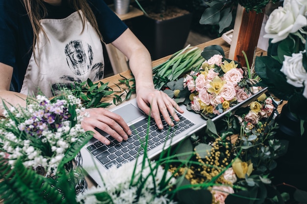 Fiorista che lavora con il computer portatile