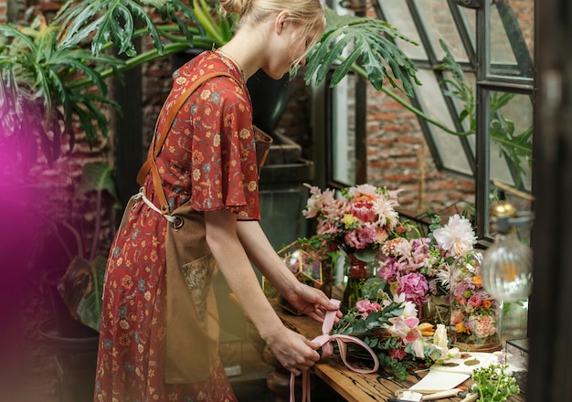 Fiorista che lega un nastro su un bouquet a