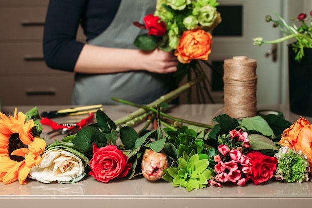 Fiorista con bouquet di rose al lavoro.