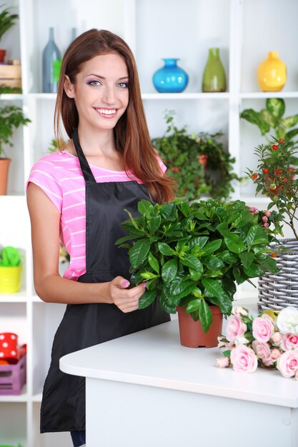 Fiorista di bella ragazza con fiori nel negozio di fiori