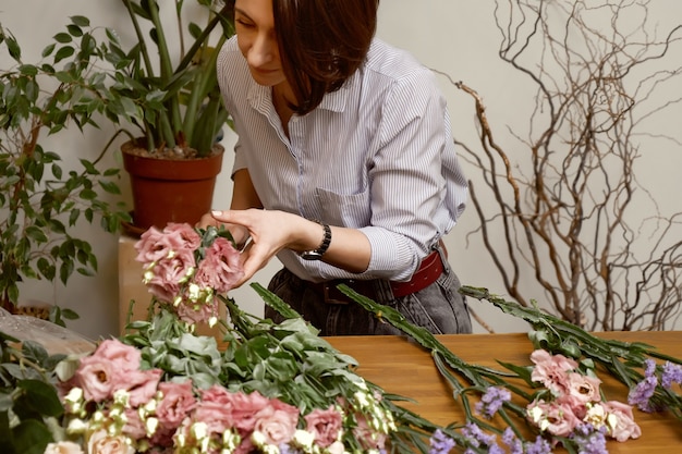 Fiorista di giovane donna nel suo studio facendo un bel bouquet