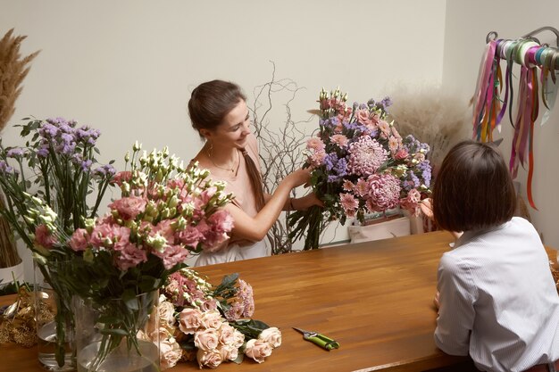 Fiorista di giovane donna nel suo studio facendo un bel bouquet