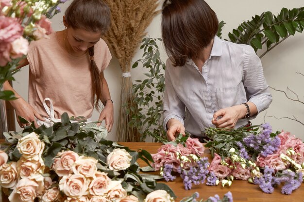 Fiorista di giovani donne nel suo studio facendo un bellissimo bouquet