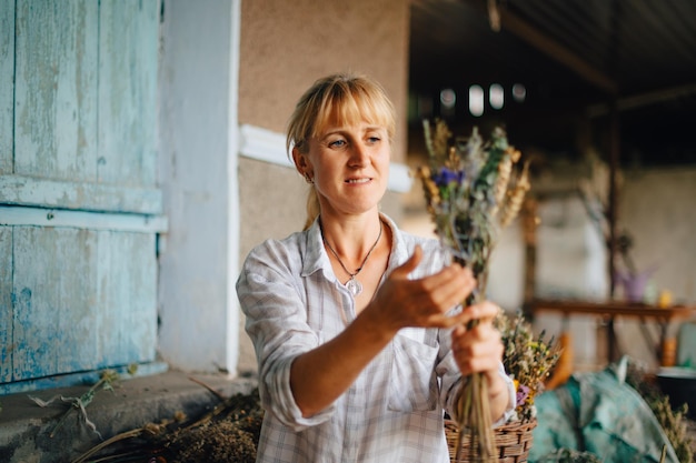 fiorista donna rurale che crea un bellissimo bouquet di fiori secchi per le vacanze fa una composizione