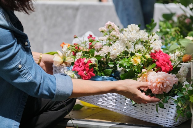 Fiorista femminile che fa composizioni floreali all'aperto Flusso di lavoro per la creazione di cestini di fiori