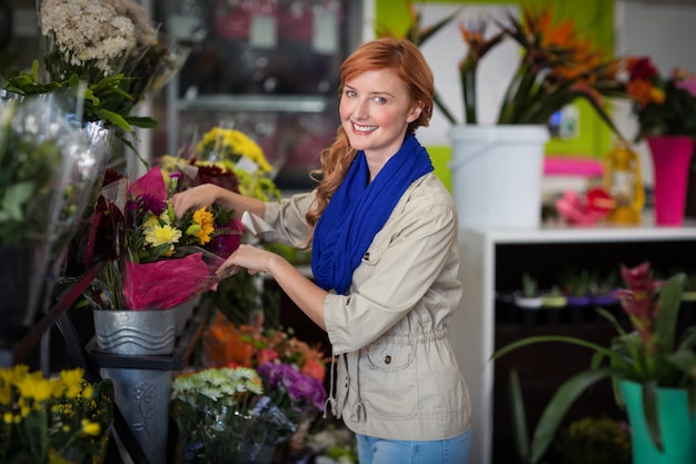 Fiorista femminile che organizza il mazzo del fiore