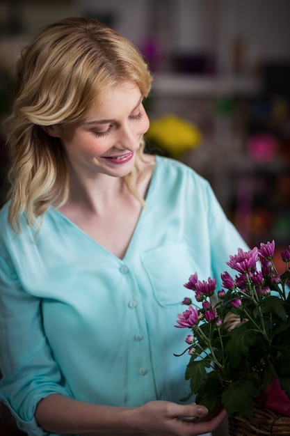 Fiorista femminile che organizza la merce nel carrello dei fiori