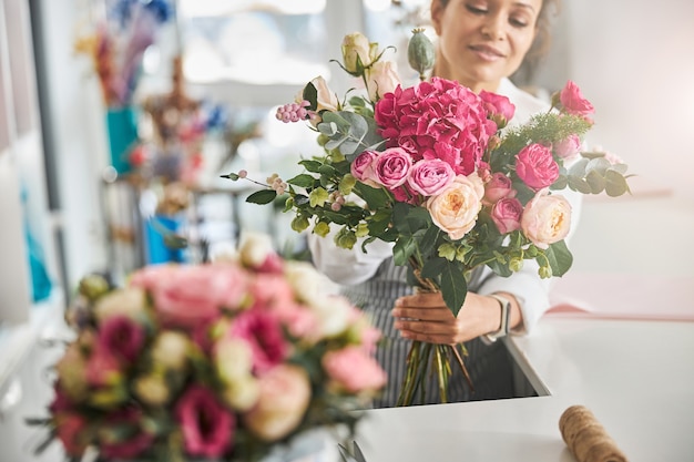 Fiorista professionista in posa con una splendida composizione floreale