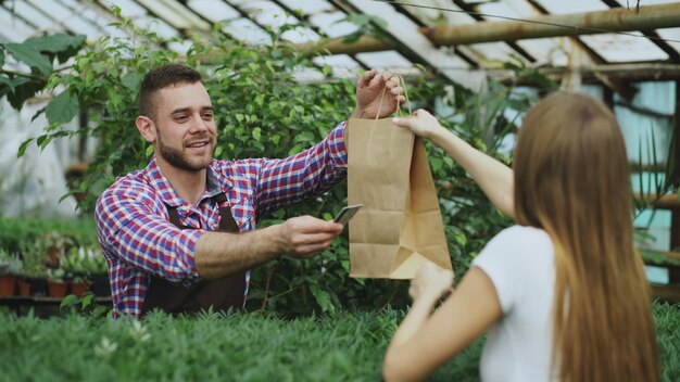 fiorista venditore sorridente che lavora nel garden center