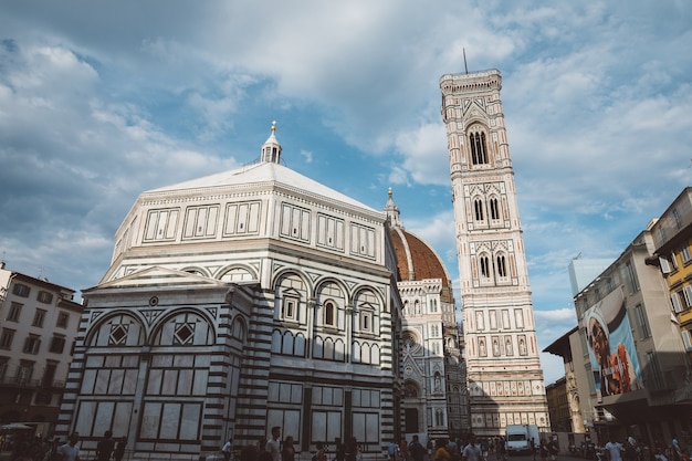 Firenze, Italia - 24 giugno 2018: Vista panoramica del complesso del Duomo: Battistero di San Giovanni, Cattedrale di Santa Maria del Fiore e Campanile di Giotto. La gente cammina in Piazza del Duomo in un giorno d'estate