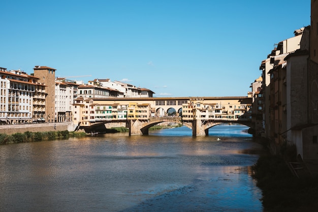 Firenze, Italia - 26 giugno 2018: La vista panoramica sul Ponte Vecchio (Ponte Vecchio) è un ponte ad arco segmentale in pietra medievale chiuso sul fiume Arno, a Firenze. Giornata estiva e cielo azzurro