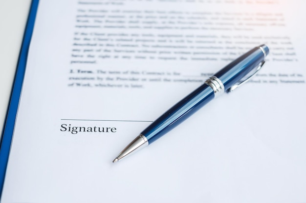 Firma con penna sui documenti contrattuali L'accordo contrattuale approva la legge e i concetti di affare