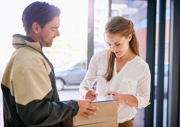 Firma di consegna uomo e donna con pacco per corriere consegna con ricevuta per azienda con lampadina per lenti spedizione di affari e pacco per cliente sul posto di lavoro con scrittura per conferma dell'ordine