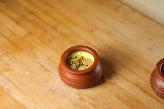 Firni phirni anf kheer con noci servite in pentola isolata sul tappetino vista dall'alto del bangali indiano e del dolce pakistano mithai