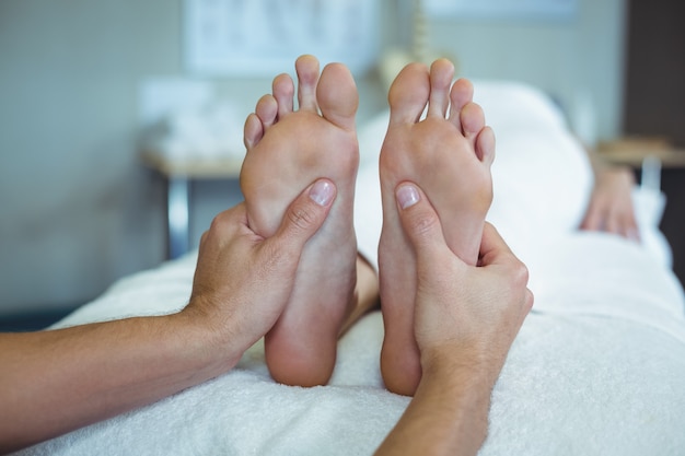 Fisioterapista che dà massaggio ai piedi a una donna