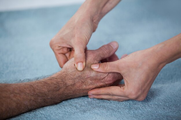 Fisioterapista che dà massaggio della mano al paziente