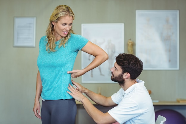 Fisioterapista che esamina la parte posteriore della donna