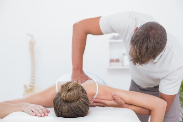 Fisioterapista che fa massaggio alla schiena al suo paziente