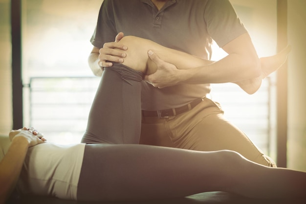 Fisioterapista che fa terapia del ginocchio a una donna