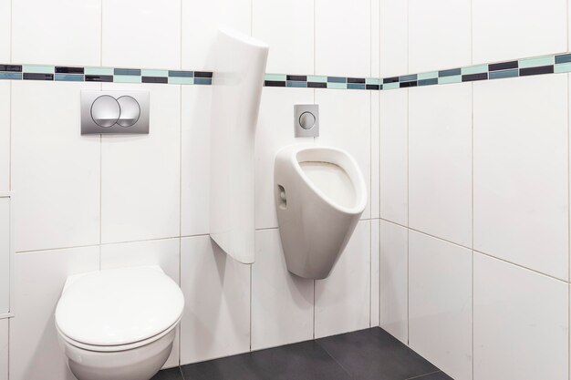 Fissature idrauliche bagno e urinario sul muro in un bagno pubblico