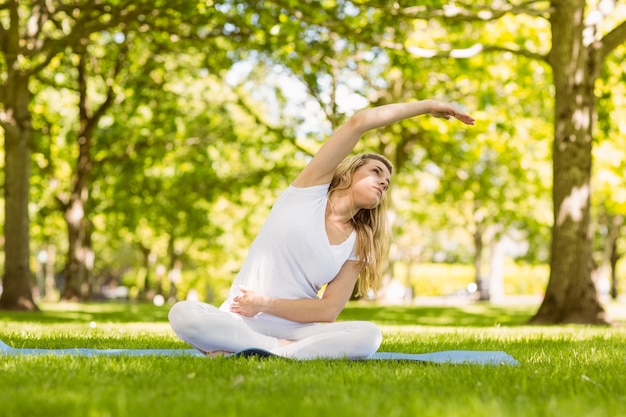 Fit bionda facendo yoga nel parco