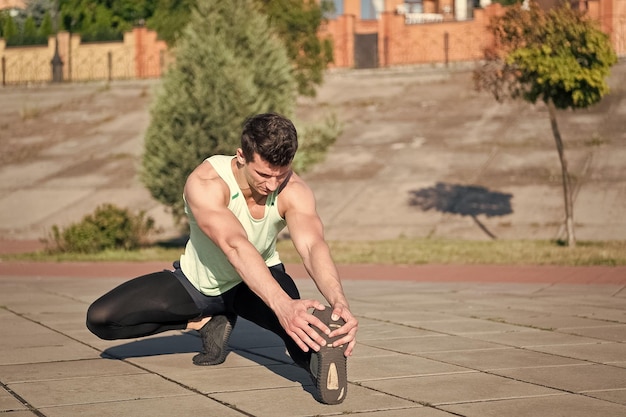 Fit macho in tuta sportiva sul paesaggio urbano