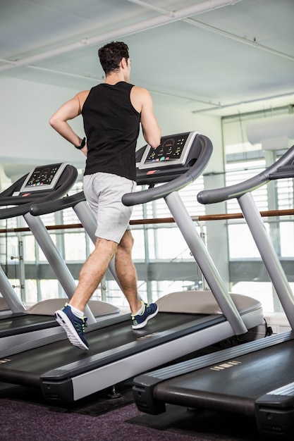 Fit uomo che corre sul tapis roulant in palestra