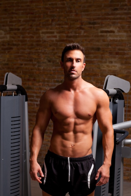 fitness a forma di muscolo uomo in posa sulla palestra