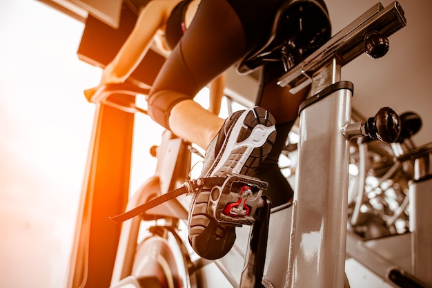 Fitness donna che lavora sulla cyclette in palestra concetto di esercizio fitness e stile di vita sano