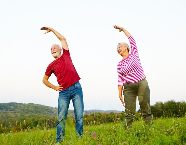 fitness senior all'aperto donna uomo stile di vita sport attivo esercizio fisico sano fitness pensione stretching coppia anziana.