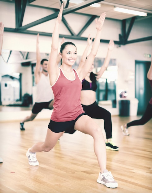 fitness, sport, allenamento, palestra e concetto di stile di vita - gruppo di persone sorridenti che si esercitano in palestra