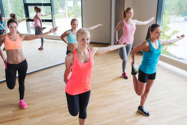 fitness, sport, allenamento, persone e concetto di stile di vita - gruppo di donne che allungano la gamba in palestra