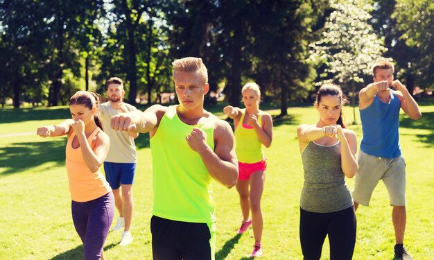 fitness, sport, arti marziali, autodifesa e concetto di stile di vita sano - gruppo di amici adolescenti o sportivi che si esercitano e al campo di addestramento