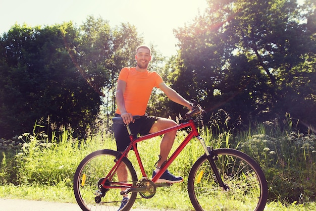 fitness, sport, persone e concetto di stile di vita sano - giovane felice in bicicletta all'aperto